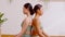Calm of wellness Couple Asian young woman sitting back to back on yoga mat doing breathing exercise yoga lotus pose together.Yoga