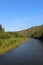 Calm wide river, curving at the foot of a high mountain