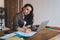 Calm woman taking notes while working on research work in hostel room