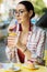 Calm woman touching a sipping straw while holding a glass of lemonade