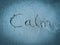 Calm, word written on blue sand