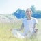 Calm yoga woman wearing soft white in connection to nature