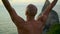 Calm yogi meditating ocean cliff closeup. Muscular athletic back at sunset sea
