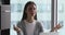 Calm young businesswoman sitting at table, making mudra gesture.