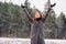 A calm young girl on a January day in a winter climb holds her hands up and catches small snowflakes.