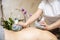 Calm young woman enjoying massage with herbal bags