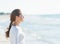 Calm young woman looking into distance at seaside