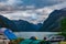 Calming view on camping people by the fjord shore against mountains and dramatic clouded sky