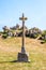 Calvary in front of a granite outcrop under a bright sunshine in Brittany, France