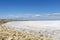 Camargue white salt flat lake, etang salt water lagoon surrounded by sand dunes, Southern France