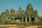 Cambodia; Jan 2020: Woman standing alone at the entrance of the Bayon temple, thousand faces temple. Ancient monument built by the