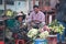 Cambodian female street vendor of flowers folding lotus flower while sitting and selling her products in the fresh market