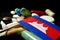 Cambodian flag with lot of medical pills isolated on black background