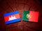 Cambodian flag with Portuguese flag on a tree stump isolated