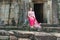 Cambodian girl at the entrance to Bayon temple in Angkor Thom, C