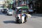 Cambodian male of sugarcane juice street vendor ride the three wheels motorcycle of his Kiosk that can move to various places