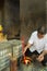 Cambodian senior lighting incense in Angkor temple