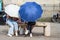 Cambridge, UK, August 1, 2019. Girls sitting On Bench Hiding Behind the Umbrellas