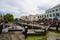 Camden Lock with shops in the background and a small number of people waiting for a narrow boat to pass