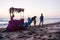 Camel on beach with a hat, garlands and a palanquin