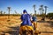 Camel caravan in Sahara desert, Morocco. People in blue dressing Bedouin ride camels in sand dunes in Africa. There are palm trees