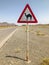 Camel cross sign on desert road