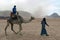 camel driver leading a tourist for desert visit on the camel