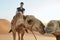 Camel riding in desert