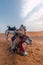 Camels sitting on the hot sand in the desert under the blue sky