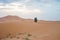 Camels walking on sand dunes during sunset in Erg Chebbi desert, near Merzouga, Sahara Desert