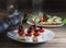 Camembert canape of cherry tomatoes with olives and ham with vegetables and quail eggs