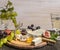 Camembert, Dor Blue, Gorgonzola, honey, grapes and wine on a cutting board wooden rustic background top view close up