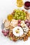 Camembert, grapes, wine and snacks on a white table, top view