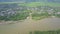 Camera approaches wide river with villages on banks