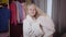 Camera approaching to charming Caucasian girl drying hair with towel. Portrait of smiling child resting in her room on