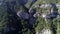 Camera approaching to the forested slope with rocks on a sunny summer day. Shot. Aerial of many green spruce trees