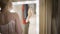 Camera approaching to reflection of happy stylish woman in dressing room. Portrait of young Caucasian rich lady choosing