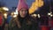 Camera approaching to young charming caucasian woman standing on city market and smiling. Portrait of pretty girl in