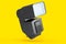 Camera external flash speedlight isolated on yellow background.