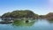 Camera Flies above Boat Sailing along Floating Village and Farms