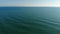Camera flies over the blur ocean waves to the clean horizon. The camera flies forward over the sea to the clear horizon
