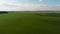 The camera flies over a field of green wheat. Rich colors, beautiful shot