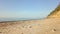 Camera flying on sandy beach with couple at the distance