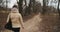 Camera following woman walking in forest