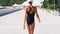 Camera follows Beautiful confident shapely woman in black swimwear