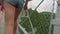 Camera follows caucasian young athletic womans feet in athletic shoes walking on suspended trellis bridge high in