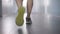 Camera follows feet of male Caucasian athlete walking in gym. Back view close-up legs of confident young man in sneakers