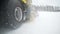 Camera follows the heavy wheel machinery, that removes snow from the road with big massive rotating brush in the snowy