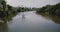 Camera follows little white boat sailing along beautiful calm river in the middle of the rainforest jungle wilderness.