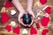 Camera lens in human hands near handicrafts heart from felt. St. Valentine s Day gift concept.